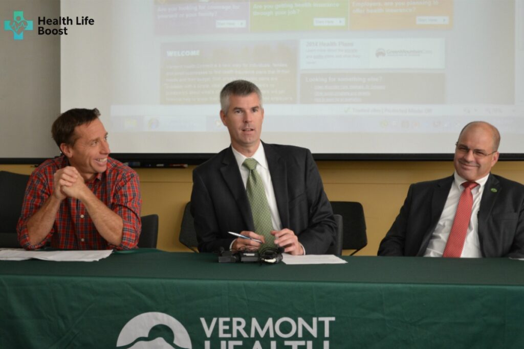 “Officials discussing Vermont Health Connect programs and health insurance plans during a public meeting.”
